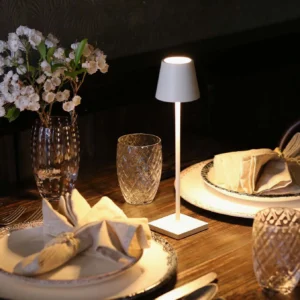 White Doku portable table lamp on formal dining table setting, elegant ambient lighting for dinner