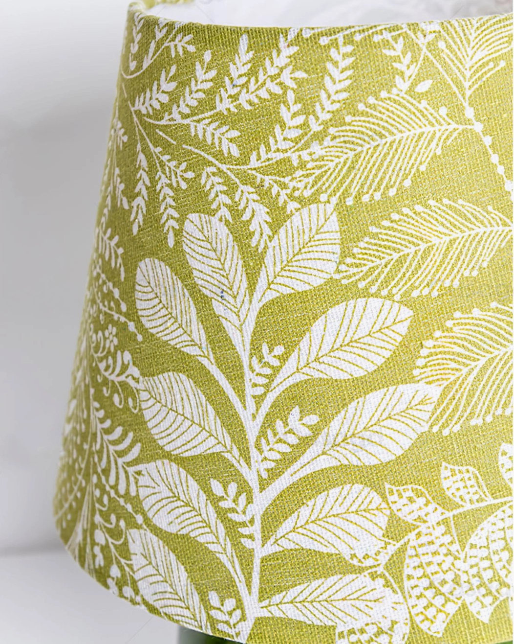 Dolly lampshade close-up showing olive green fabric with white leaf and fern botanical print pattern