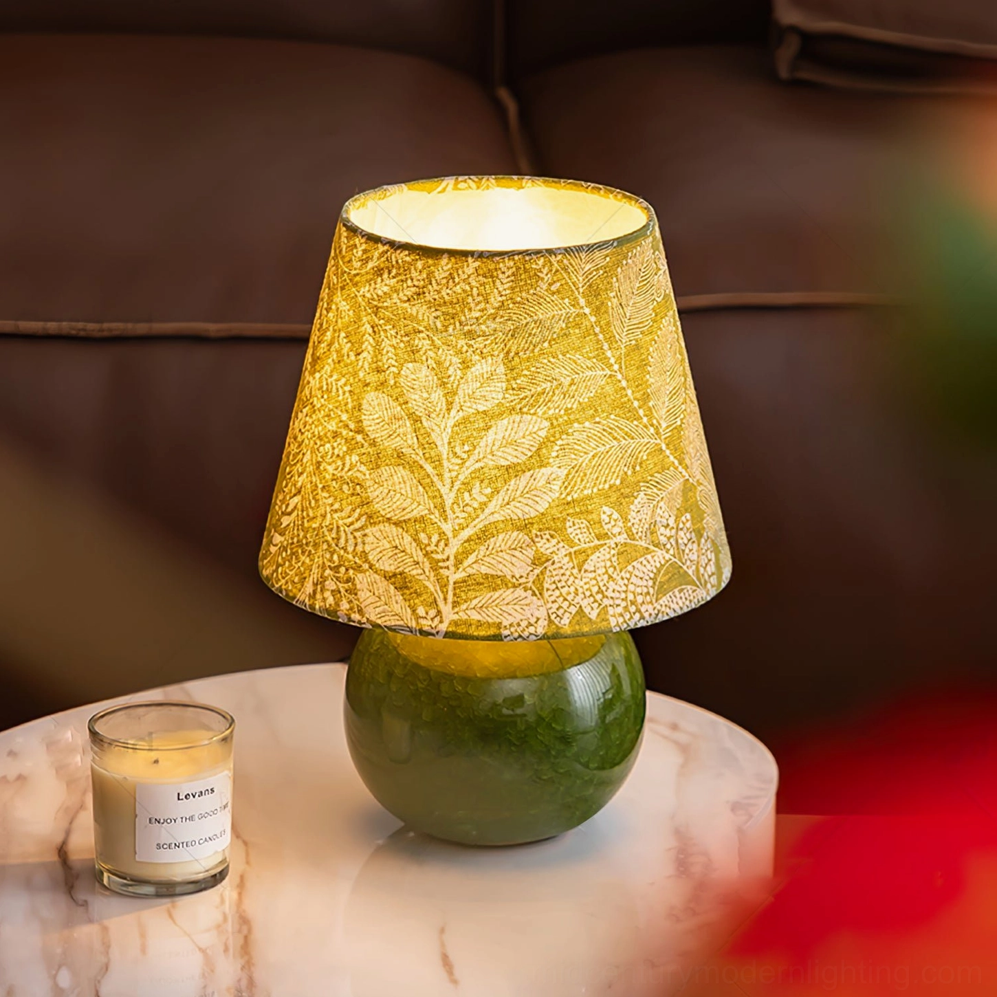 Dolly table lamp styled in modern living room with brown leather sofa, marble side table, and warm botanical glow