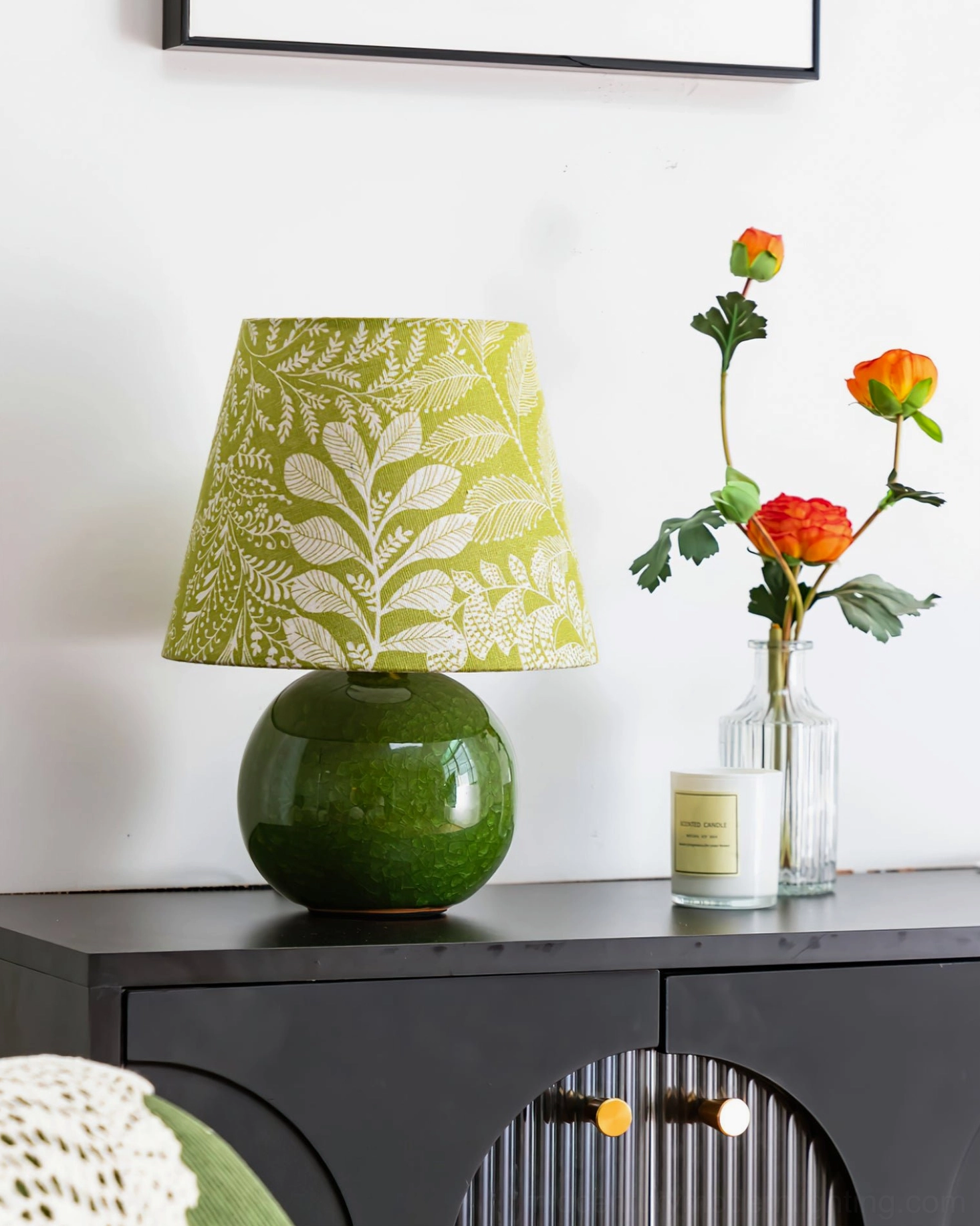 Dolly table lamp on black console table in modern entryway with floral decor and candles