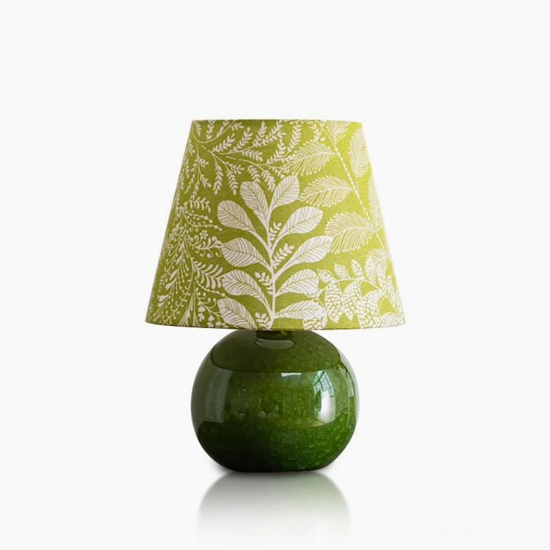 Dolly ceramic table lamp with polished olive green base and white leaf printed botanical shade, studio front view