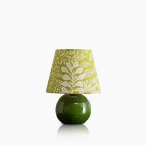 Dolly ceramic table lamp with olive green spherical base and botanical leaf print shade, front studio view