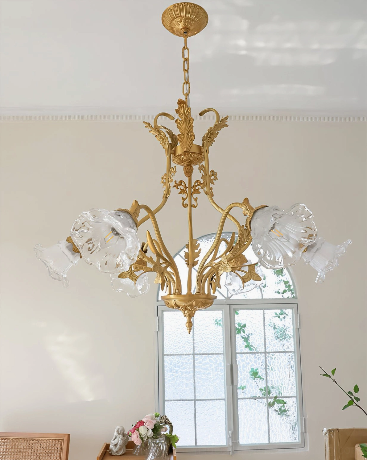 Unlit Dore brass flower chandelier displaying clear glass petals and ornate metalwork details
