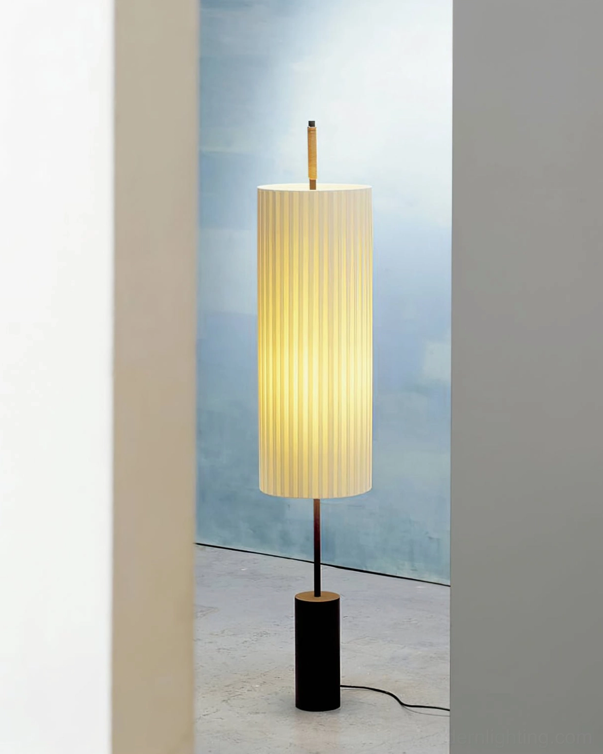 Dorica minimalist floor lamp backlit by outdoor light on modern balcony or entryway
