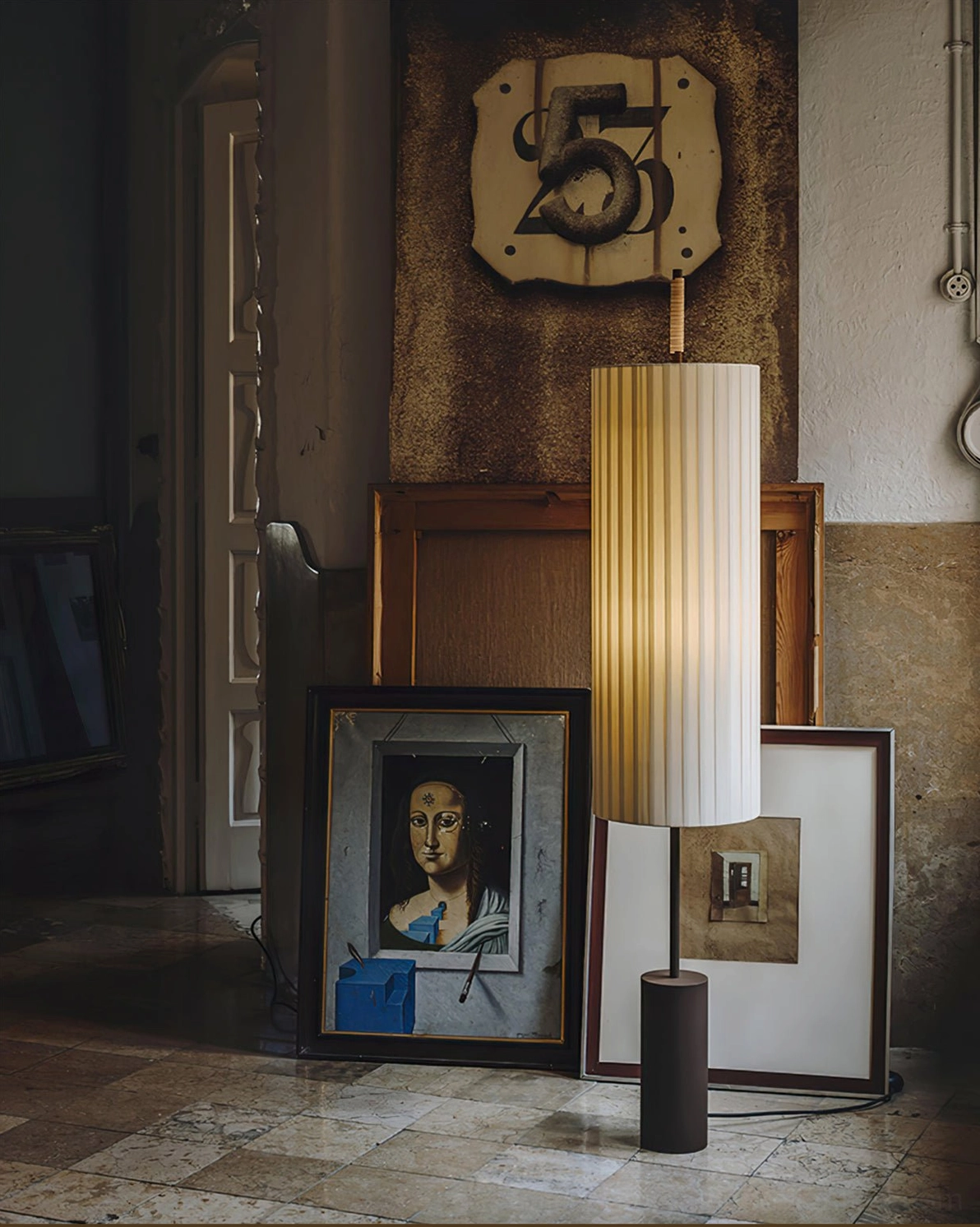 Dorica sculptural floor lamp glowing warmly in vintage art gallery setting with framed artworks