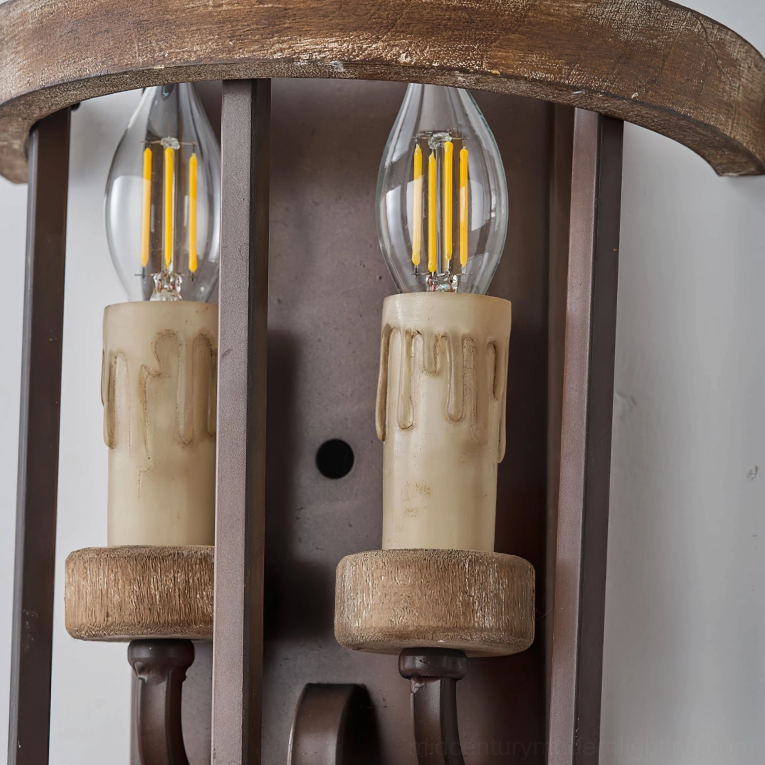 Close-up detail of double candle sconce showing LED filament bulbs, wax-drip candle covers, and wooden holders