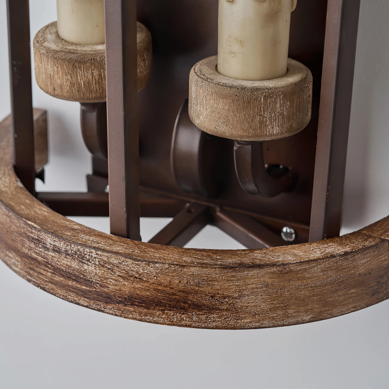 Bottom detail view of double candle wall sconce showing weathered wood trim, brown metal parts, and mounting hardware