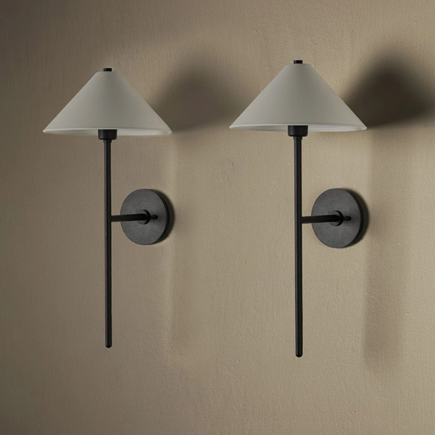 Twin cedar black wall sconces mounted symmetrically on warm beige wall, demonstrating paired installation for bedroom or living room accent lighting