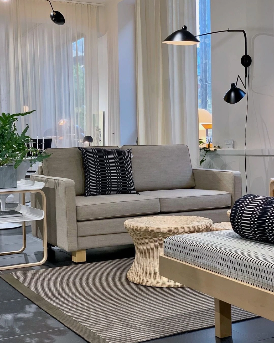 Dual-arm articulated wall lamp with multiple swiveling shades in modern lounge environment
