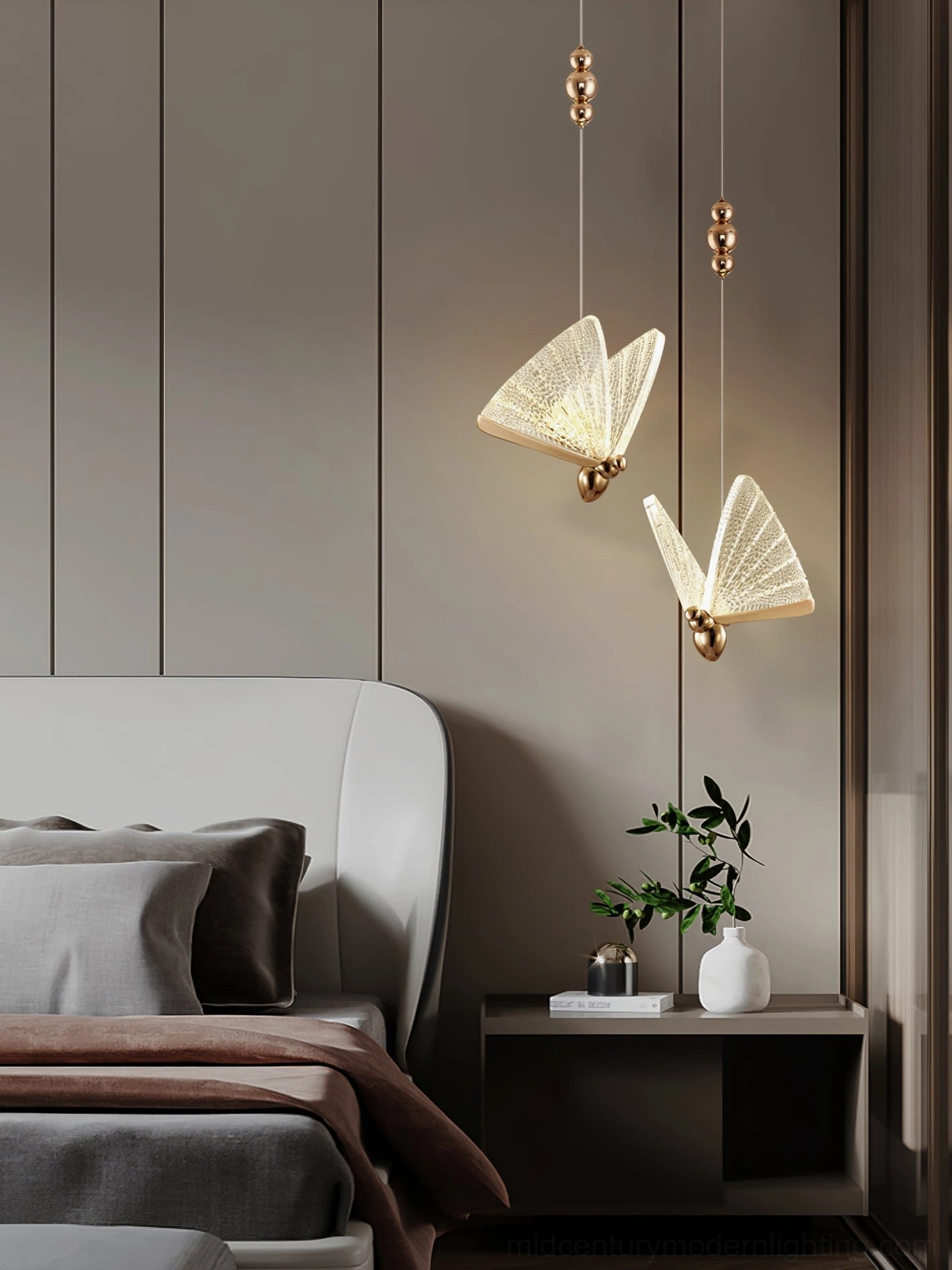 Two butterfly pendant lights in neutral modern bedroom with potted plant and gold suspension