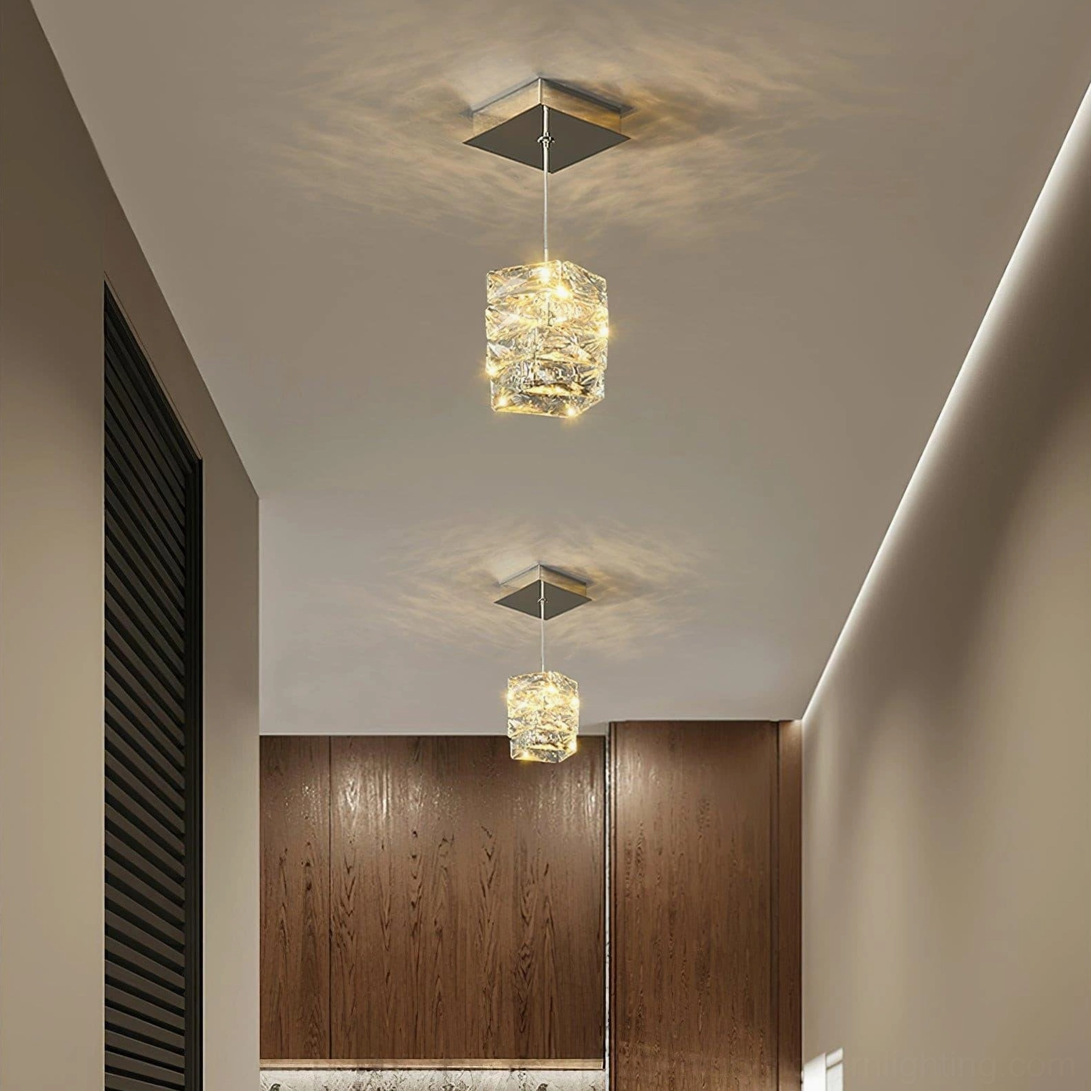 Pair of matching crystal pendant fixtures installed in residential hallway with wooden cabinetry and warm minimalist lighting