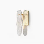 Dual-head brass wall sconce with rippled clear glass shades, front view on white background, modern luxury lighting fixture