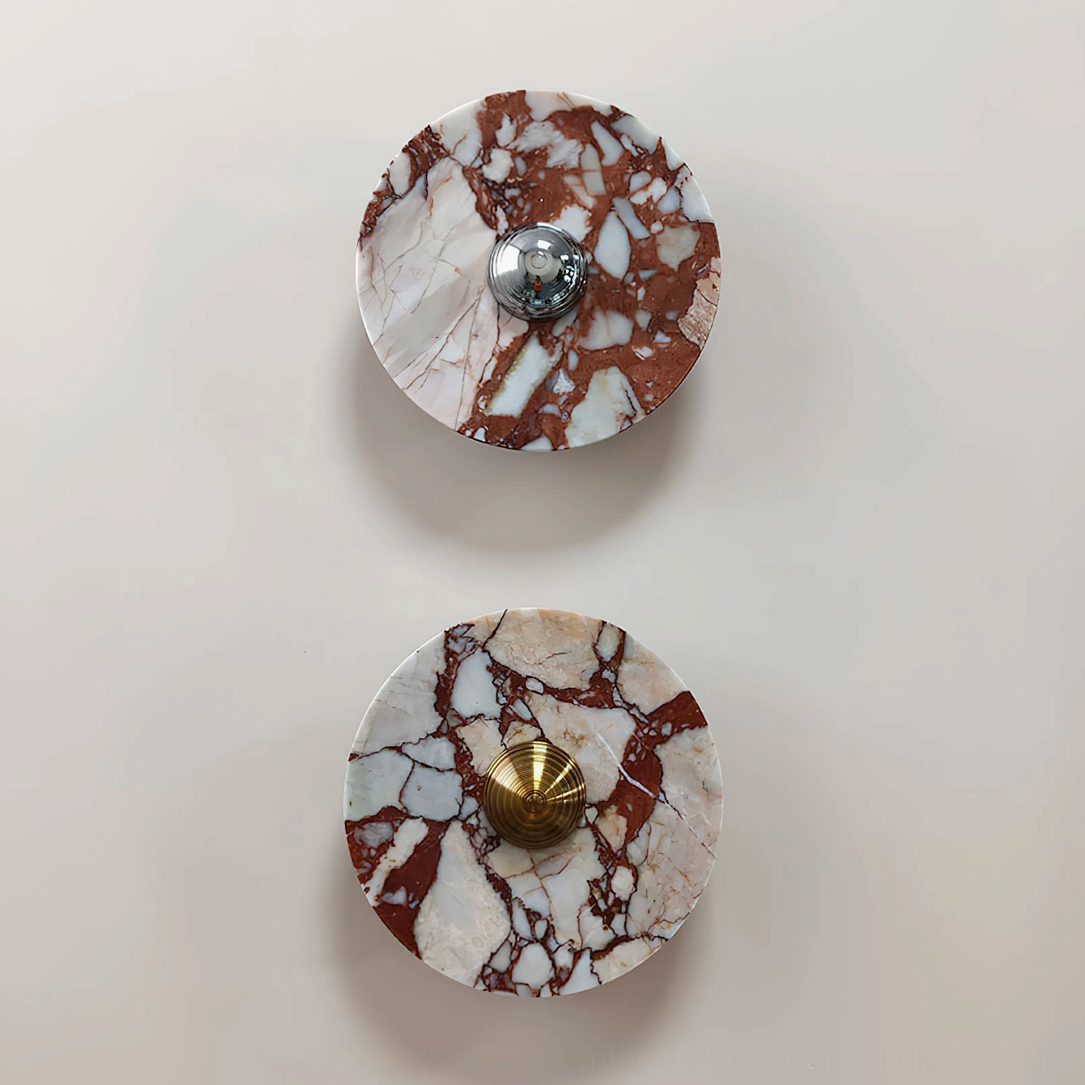 Pair of wall-mounted marble lamps with red and white tones paired with mixed chrome and brass accents on beige wall