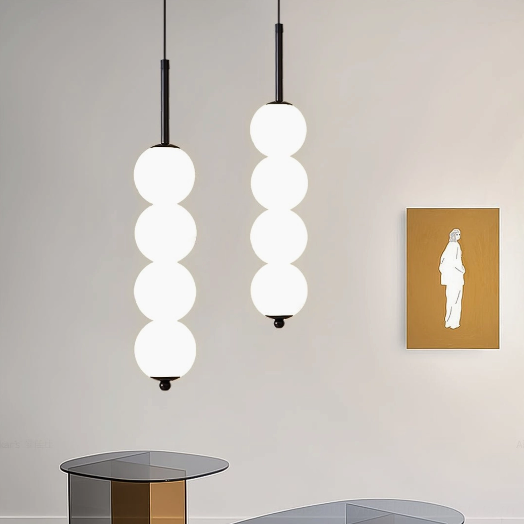 Pair of four-orb Orbet pendant lamps in black installed symmetrically over side table in living room