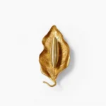 Dumaine brass leaf wall sconce frontal view against white background, sculptural metal leaf form with warm lighting