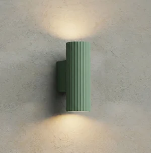 Dunbar green wall light with dual upward and downward beam illumination on concrete wall, modern minimalist lighting