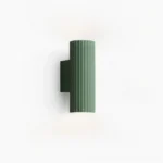 Dunbar ribbed wall sconce in green, front studio view showcasing matte aluminum texture and vertical geometric pattern