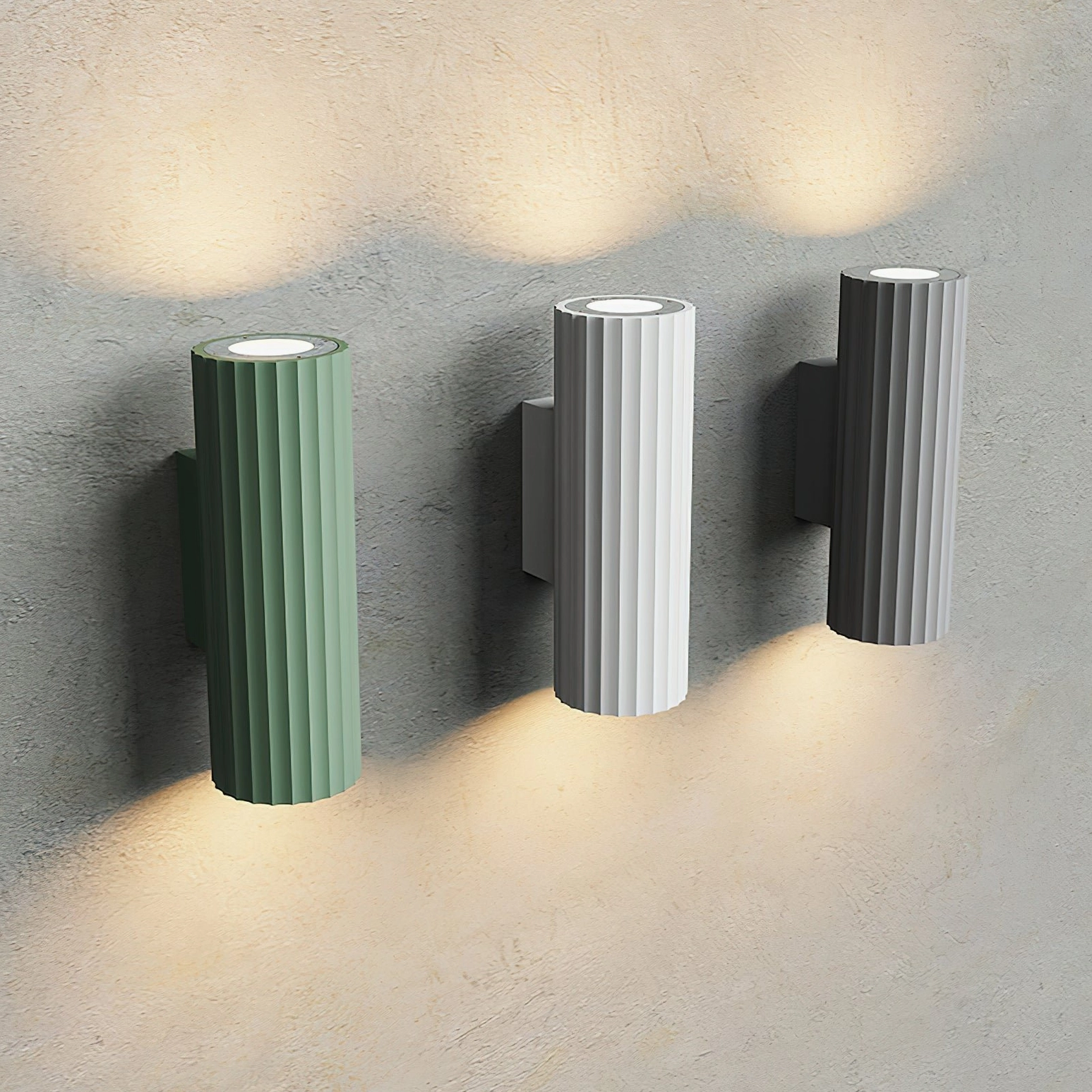 Dunbar ribbed wall sconce set in three finishes - green, white, and grey - on textured concrete wall background
