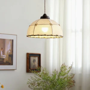 Duomo pendant light glowing warm amber in modern minimalist living room with wall art and green plant