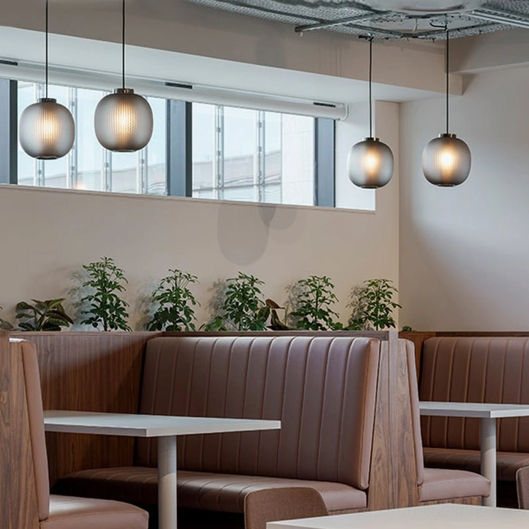 Frosted glass pendant with perforated core creating ambient light projection