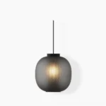 Dynamic pendant light with ribbed dark glass and perforated mesh core, front studio view
