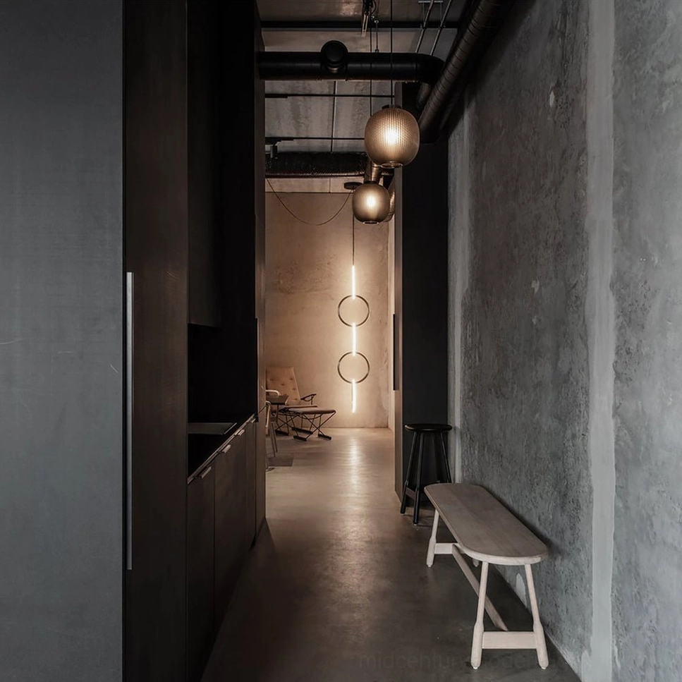 Dark glass pendant lights in industrial residential hallway with exposed ceiling pipes
