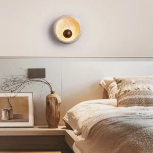 Eala travertine wall sconce mounted in modern bedroom interior design setting