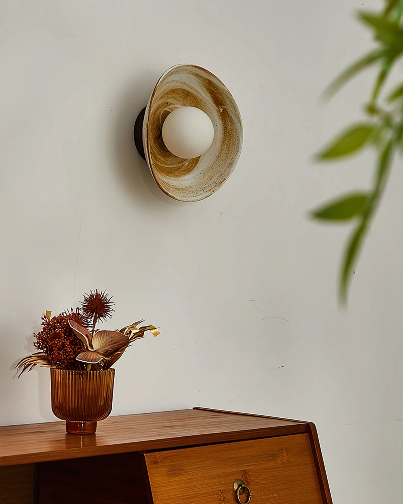 Eala wall lamp in living space with warm illumination, paired with dried flowers and green foliage