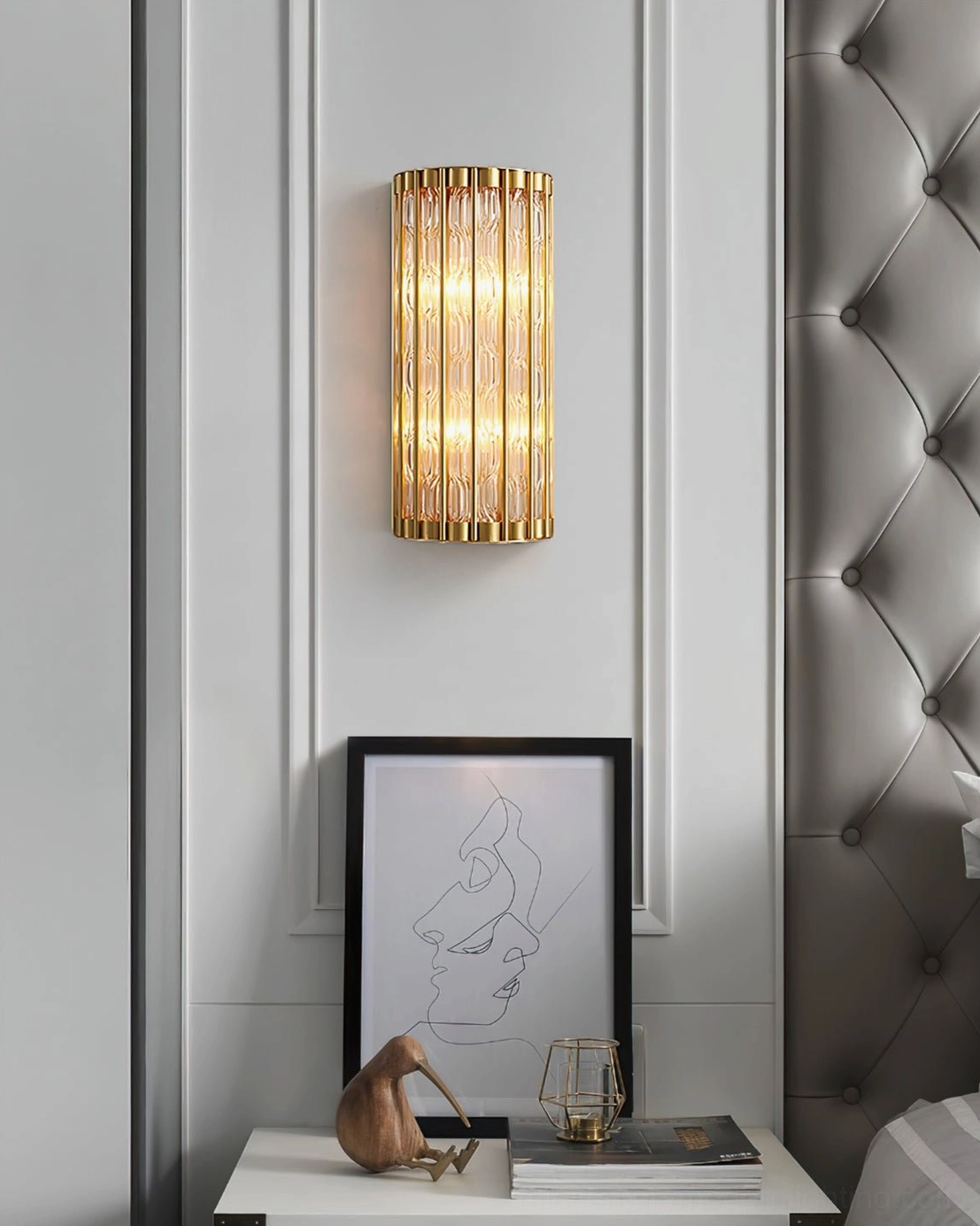 Bedroom wall light with luxe gold brass finish and ribbed glass, mounted above bedside table for accent lighting
