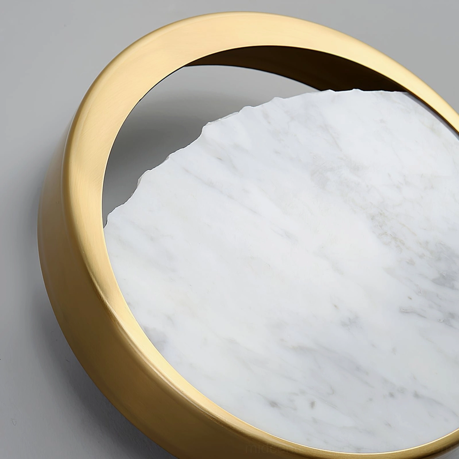 Eclipse wall lamp side view detail highlighting thick gold frame and textured marble surface