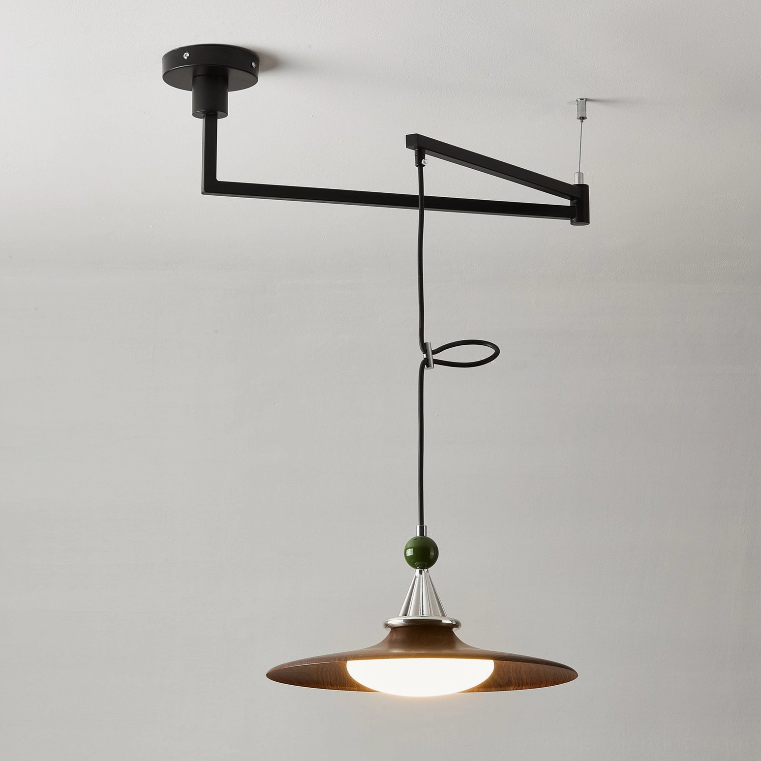 Eden swing arm pendant light casting warm ambient glow creating shadows and highlighting architectural home features
