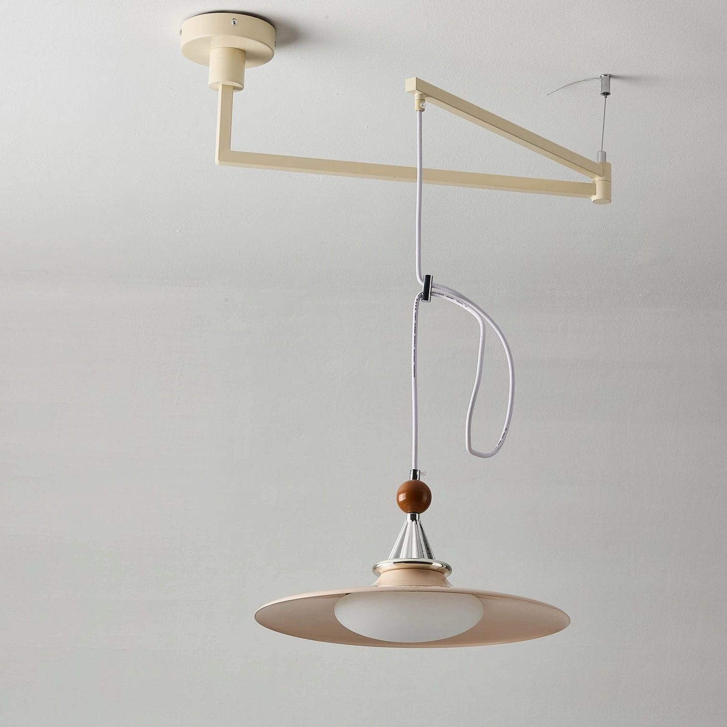 Full view of Eden swing arm pendant light with walnut and black finish, adjustable arm mechanism, and saucer-style shade against neutral background