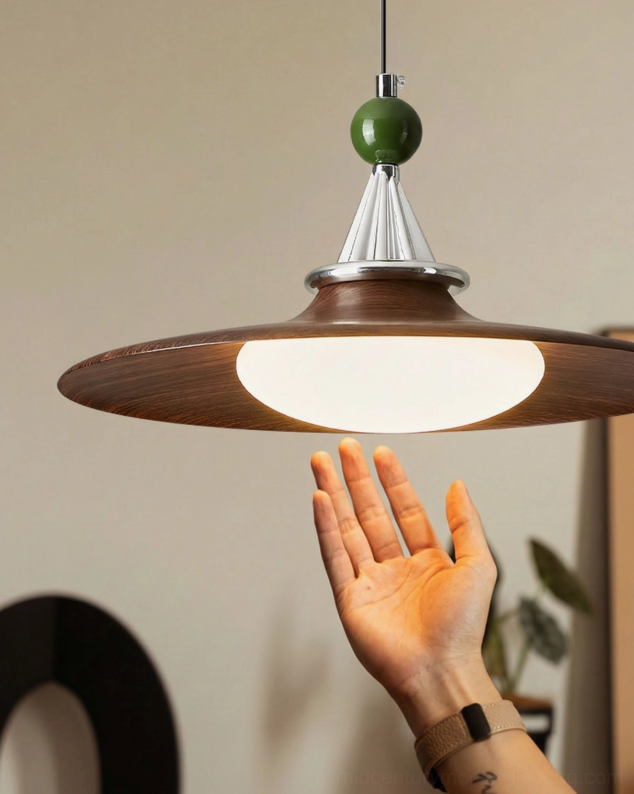 Walnut wood-grain pendant light with hand showing texture detail and scale reference
