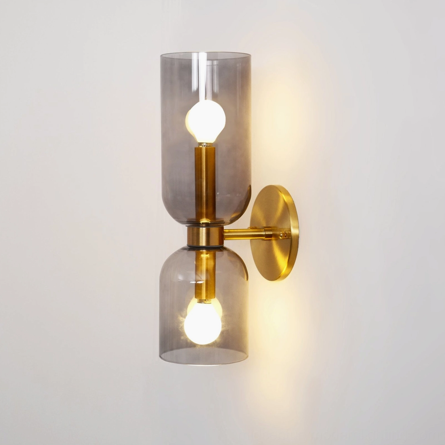 Contemporary minimalist blown glass wall lamp with transparent shade and warm brass finish