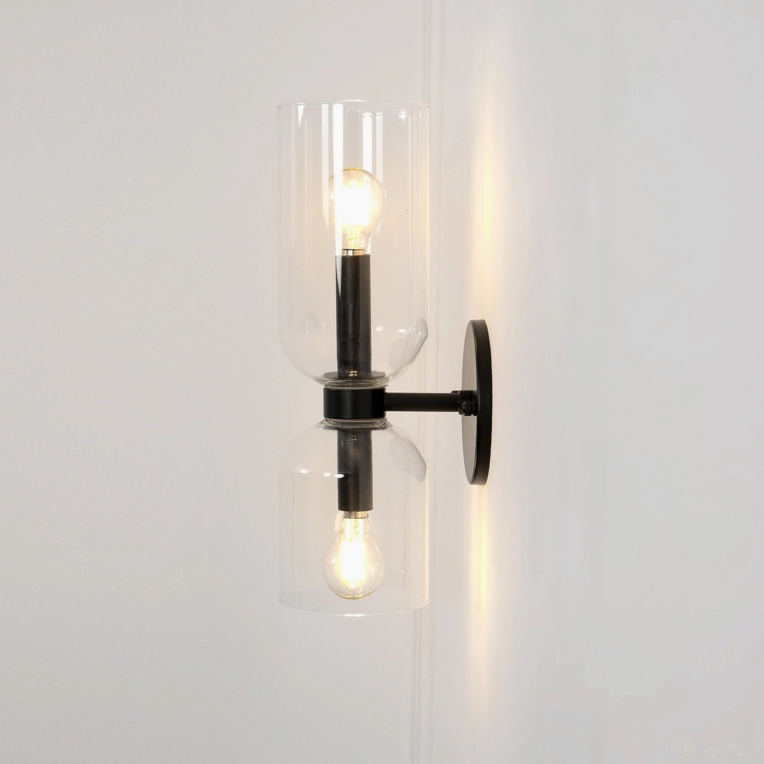 Edie glass wall lamp showing smoked shade with refined brass base in contemporary interior style