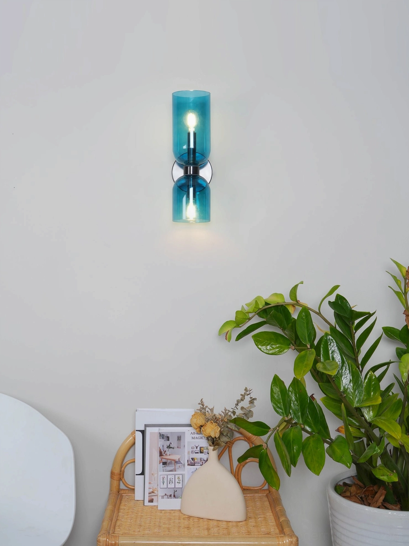 Contemporary mid-century modern sconce with hand-blown glass and polished metal finish detail view