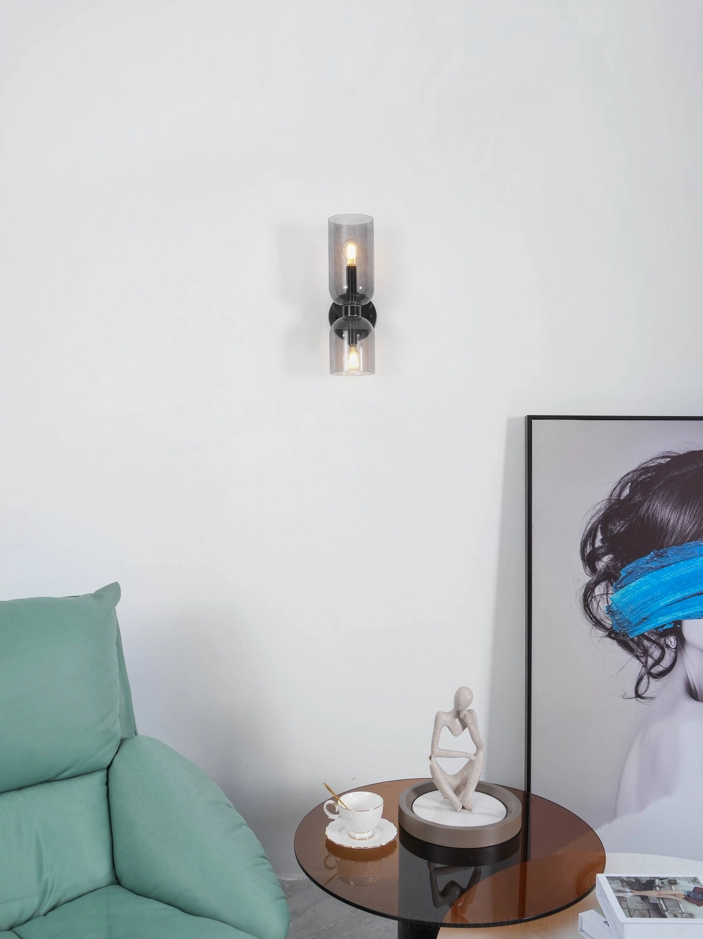 Minimalist blown glass wall sconce featuring cylindrical glass form and refined metal mounting