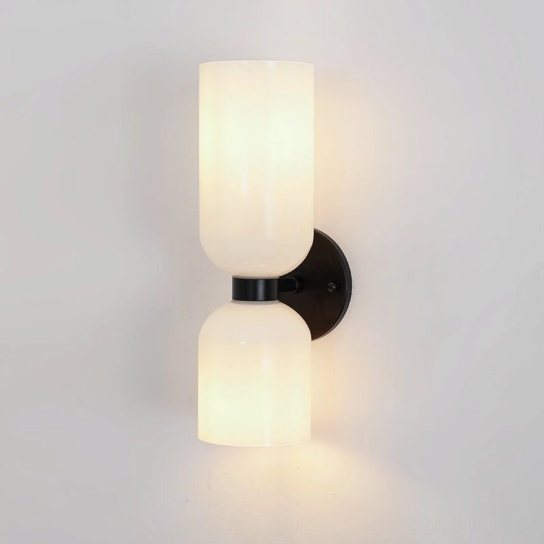 Minimalist wall sconce with white frosted glass shade and matte black metal base mounting