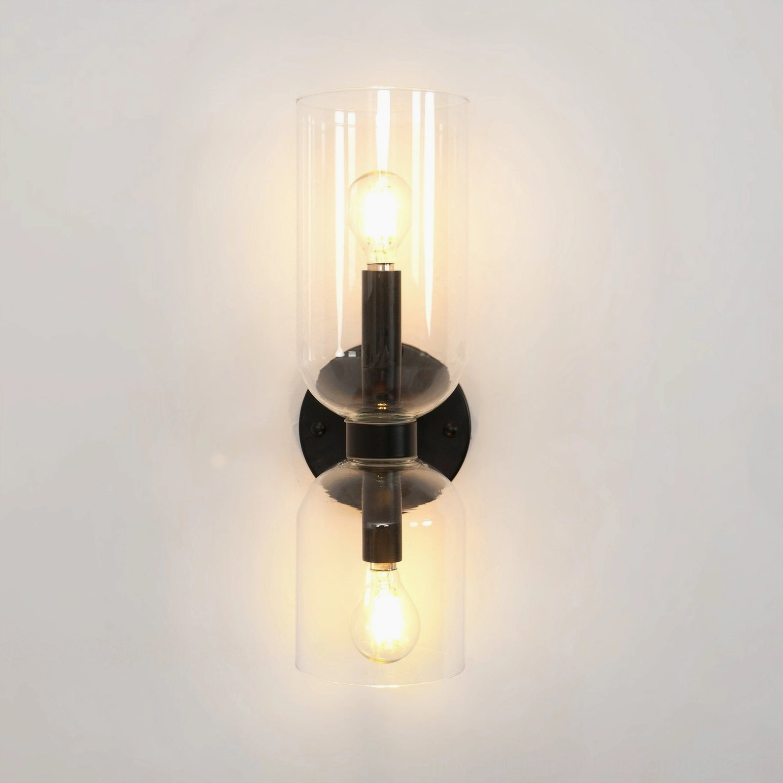 Minimalist wall sconce with transparent glass and matte black metal base showcasing modern luxury design