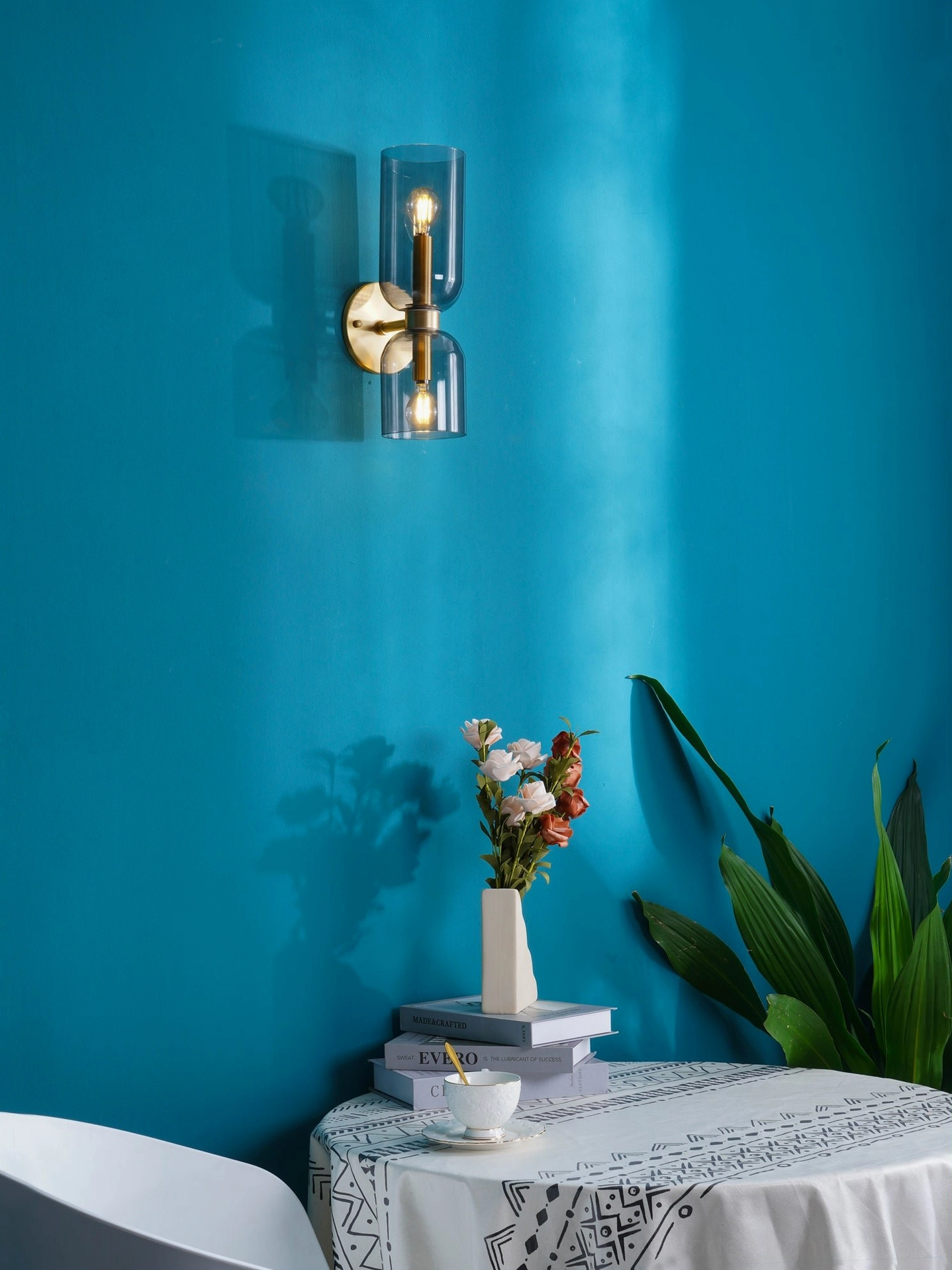Edie wall sconce installed in dining room interior with brass frame and frosted glass providing ambient lighting