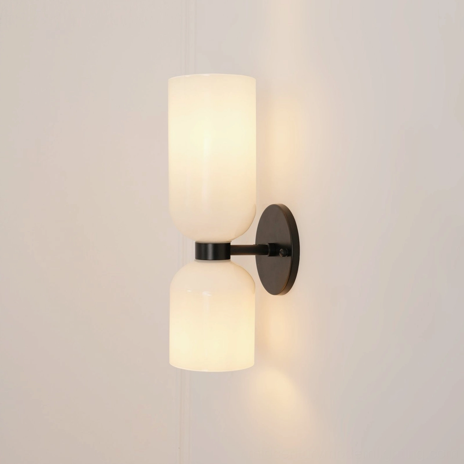 Contemporary sconce showcasing hand-blown glass craftsmanship with matte black metal finish