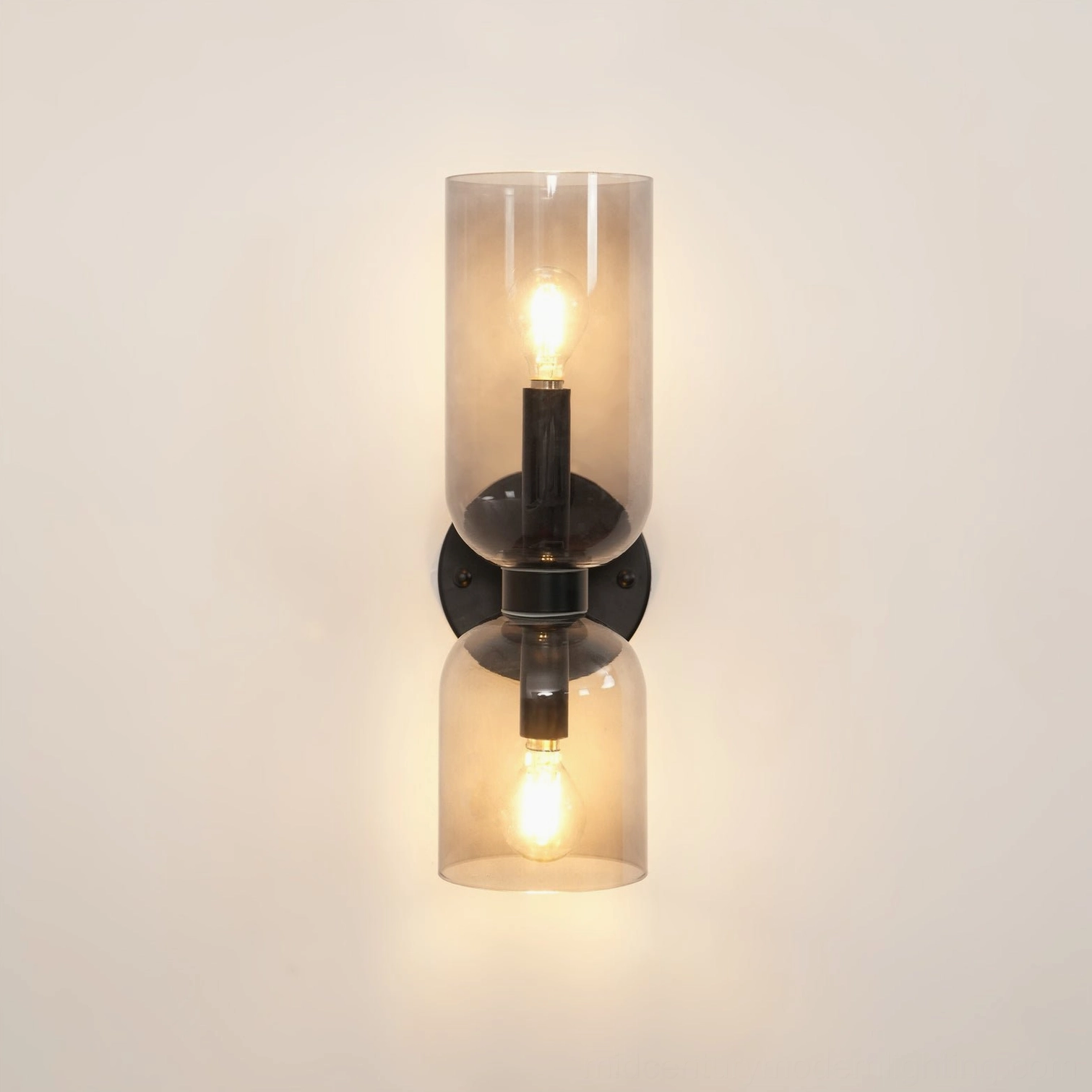 Modern sconce featuring hand-blown transparent glass with warm brass base in clean studio shot