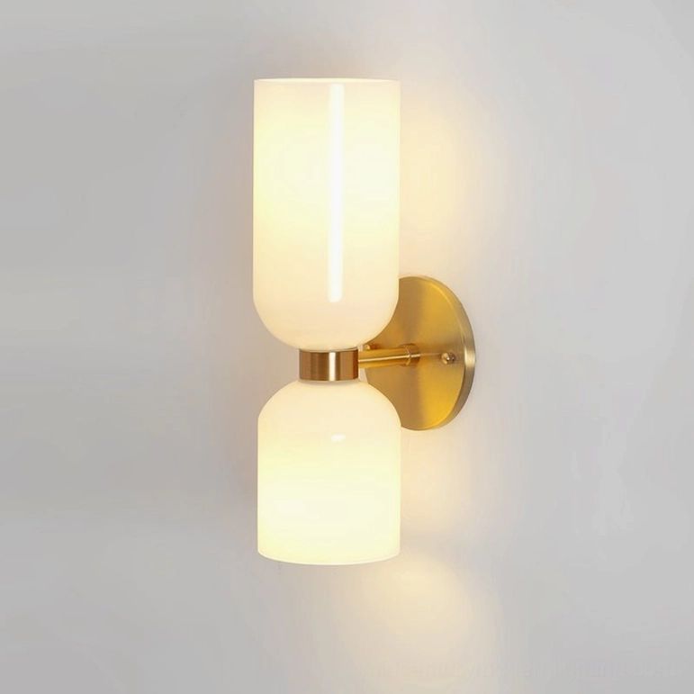Contemporary Edie wall lamp with white frosted glass shade and warm brass hardware