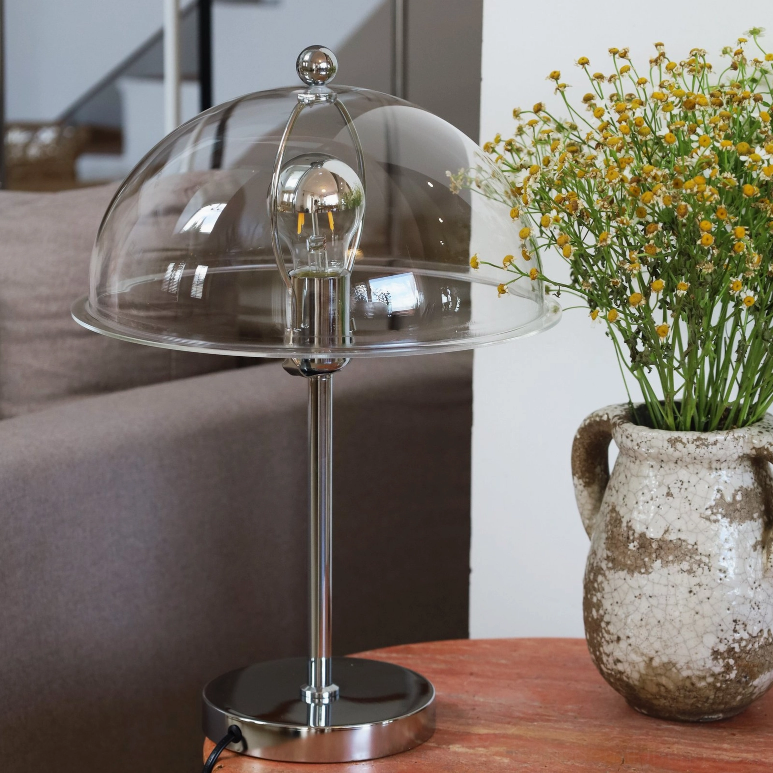 Edinburgh table lamp with clear shade in living room corner, three-quarter angled view on side table