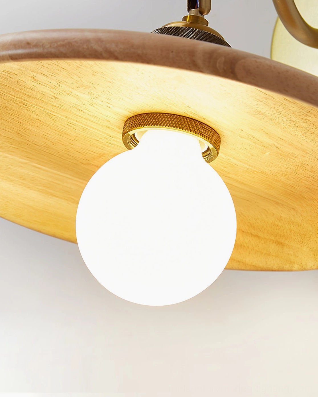 Overhead view of Edmund wall lamp shade assembly with LED bulb and brass ring fixture
