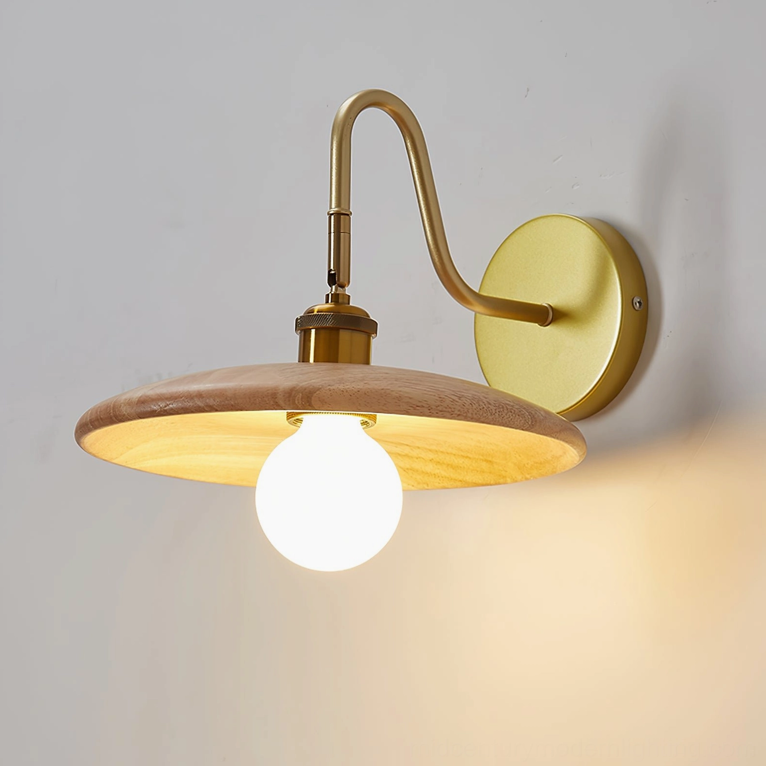 Close-up detail of Edmund wall lamp gooseneck arm and round brass mounting base