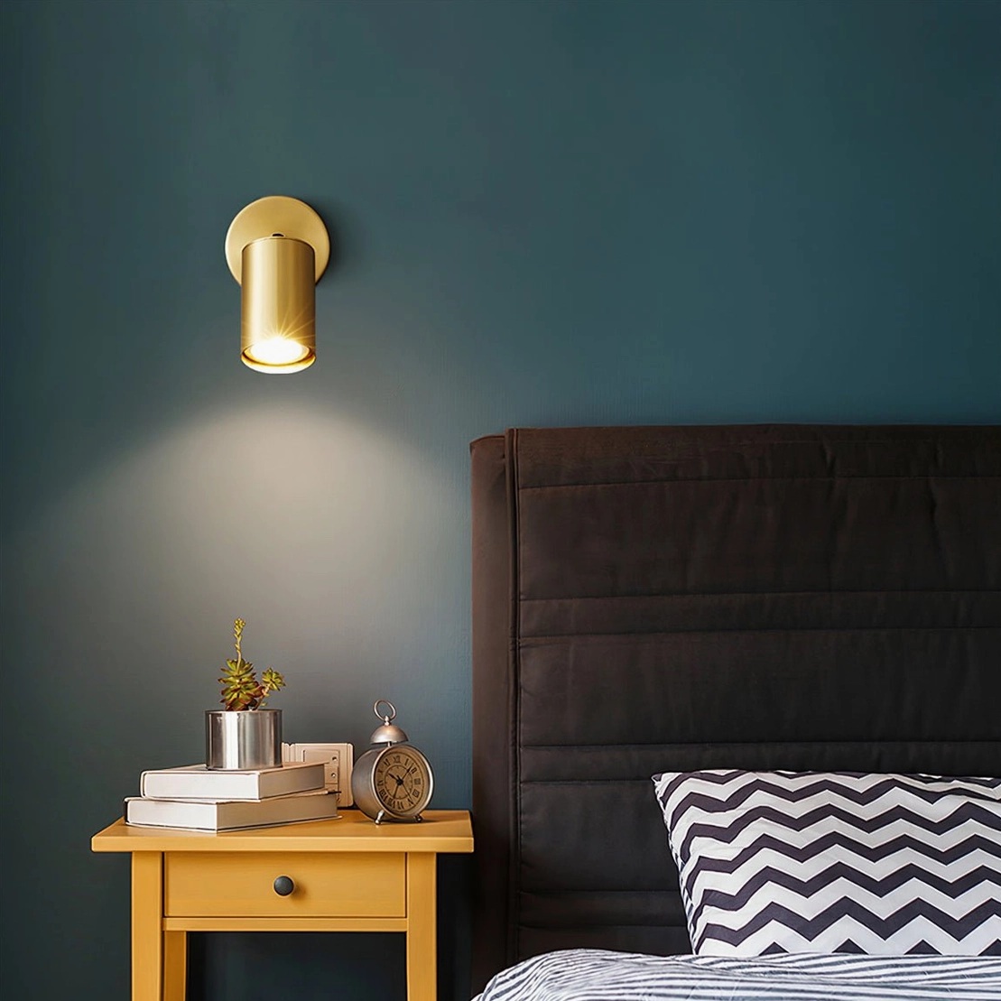 Eduard adjustable wall sconce in brass finish on teal accent wall in contemporary master bedroom