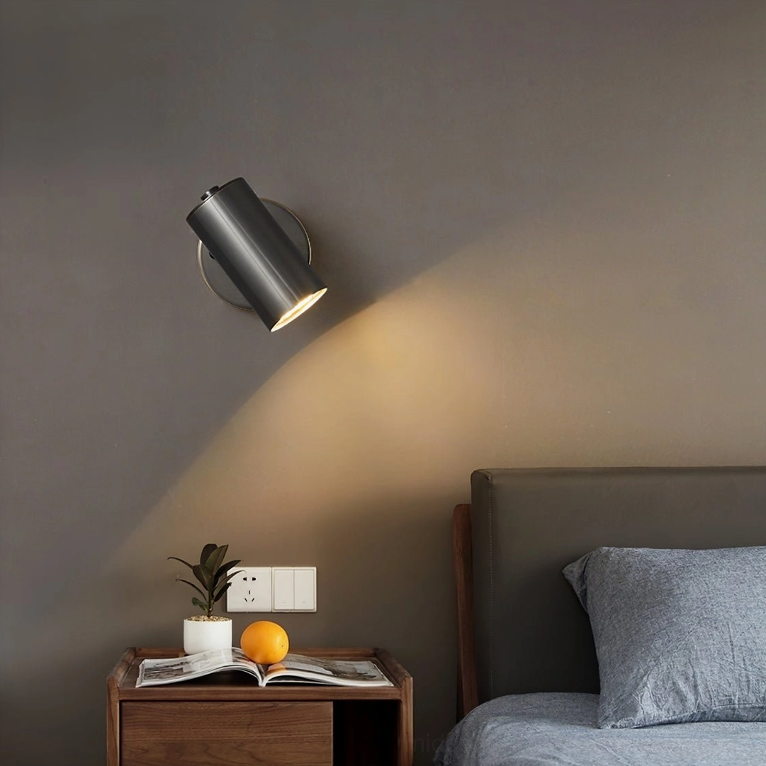 Eduard dark metal wall sconce installed above wooden nightstand in contemporary bedroom sanctuary