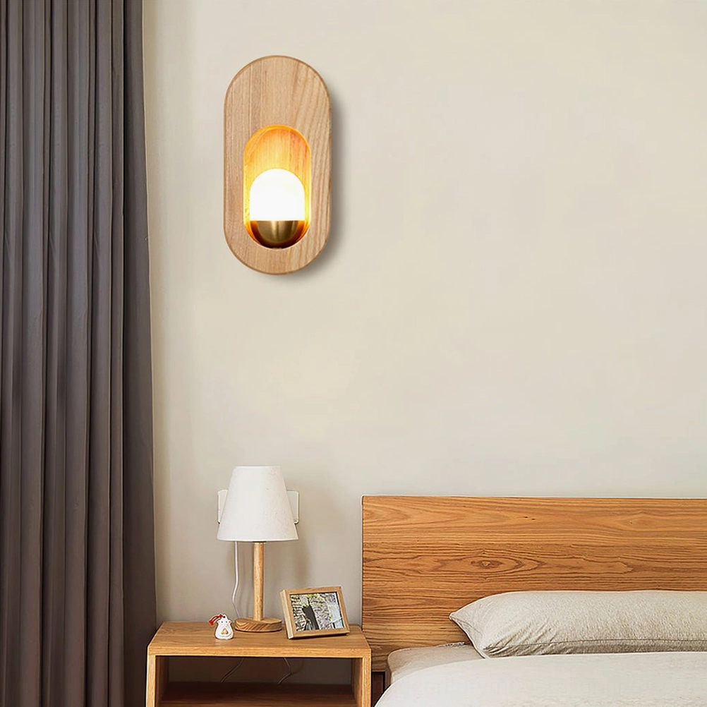 Side view of wooden egg sconce with natural wood grain visible, installed beside bed in neutral bedroom