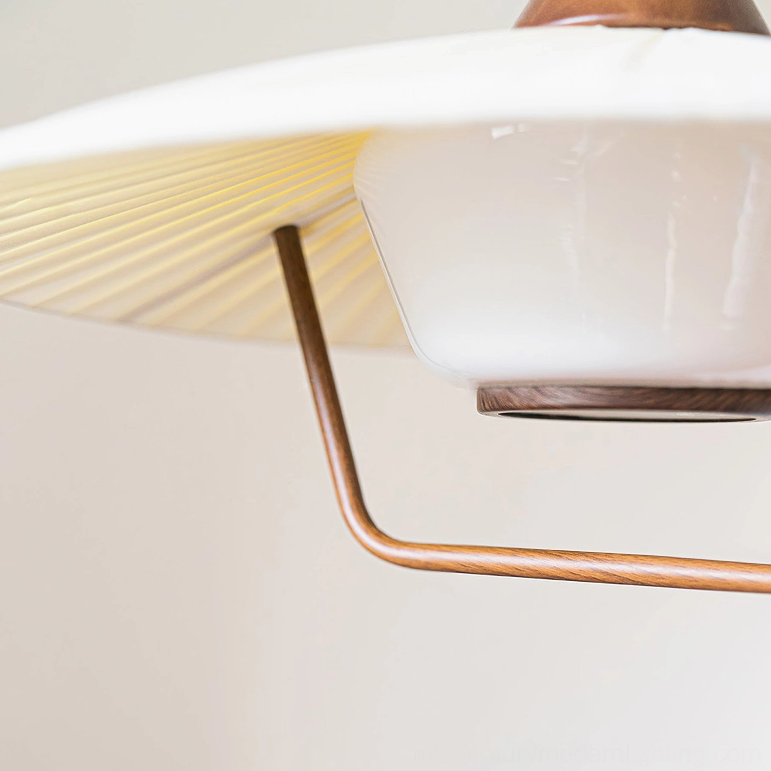 Eikon pendant lamp close-up detail showing pleated shade, frosted glass base, and walnut metal bracket